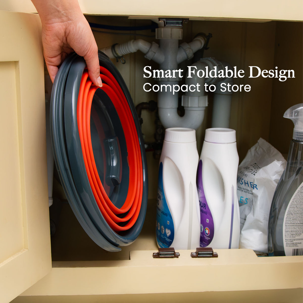 Folded bucket being slid into a cupboard under the sink beside cleaning bottles