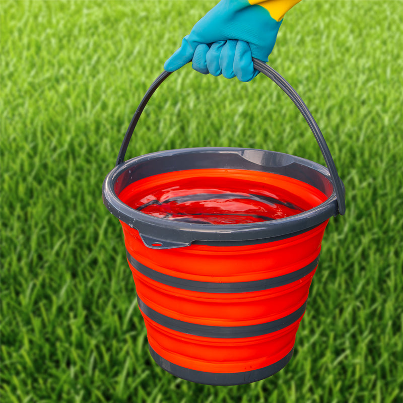 Gloved hand carrying the full folding bucket by its handle